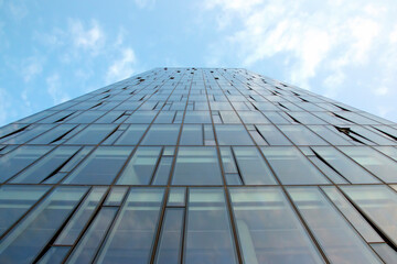 Fototapeta na wymiar Glass facade of a modern multi-storey building against the sky
