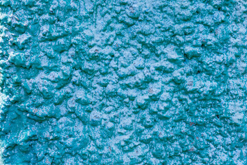 Old turquoise plaster wall texture. Retro painted putty building background with copy space....