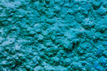 Old turquoise plaster wall texture. Retro painted putty building background with copy space. Stylish blue surface, detailed stones backdrop. Wallpaper textured screensaver front view for text design.
