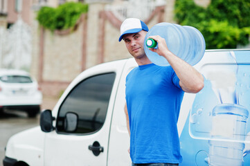 Delivery man in front cargo van delivering bottles of water.