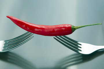 Red hot pepper with fork close-up on plate. Healthy vegetable food and vitamins