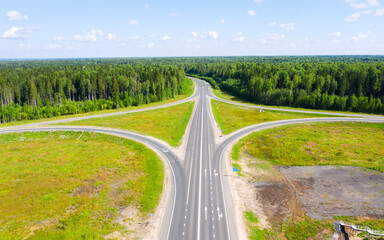 Clover or daisy, a simple and cheap type of road junction. Aerial view of highway road junction in the in the Kostroma region, Russia.