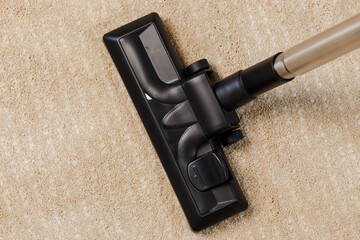 Red vacuum cleaner on a beige carpet