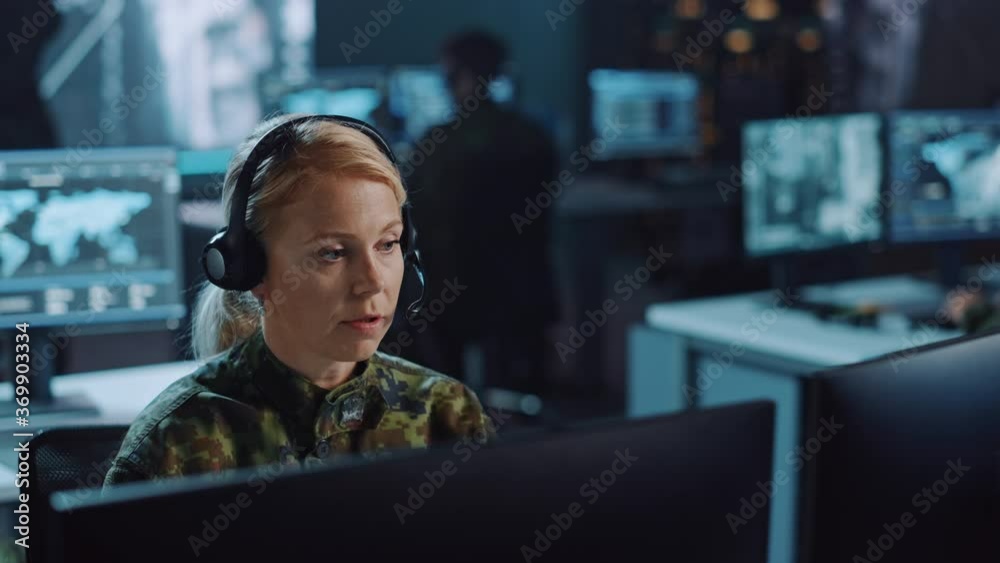 Aufkleber female military surveillance officer talking on headset in central office hub for cyber operations, 