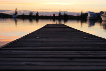 Fototapeta premium Wooden pier stretching into the lake vesijärvi at sunset. Lahti. Finland.