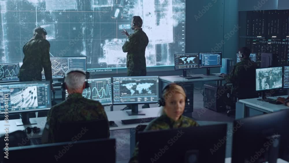Poster Military Surveillance Team of Officers Locked a Target on a Vehicle from a Satellite and Monitor it on a Big Display in Office for Cyber Operations for Managing Security and Army Communications. 