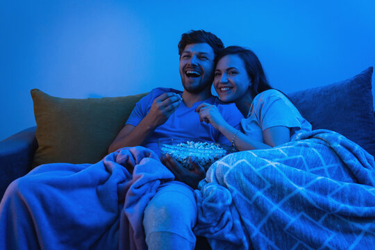 Young And Happy Couple Watching Comedy TV Show