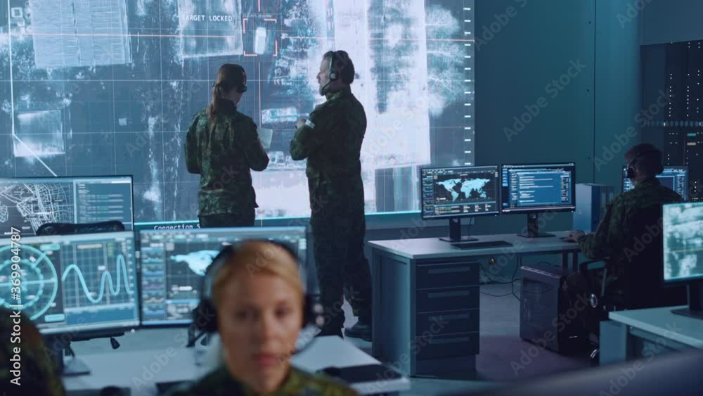 Poster Military Surveillance Team of Officers Locked a Target on a Vehicle from a Satellite and Monitor it on a Big Display in Office for Cyber Operations for Managing Security and Army Communications. 