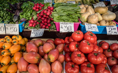 A colorful assortment of fresh fruits and vegetables neatly and attractively arranged on stands for sale at Riga Central Market, Latvia.