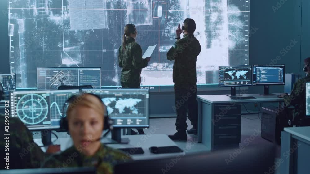 Poster Military Surveillance Team of Officers Locked a Target on a Vehicle from a Satellite and Monitor it on a Big Display in Office for Cyber Operations for Managing Security and Army Communications. 