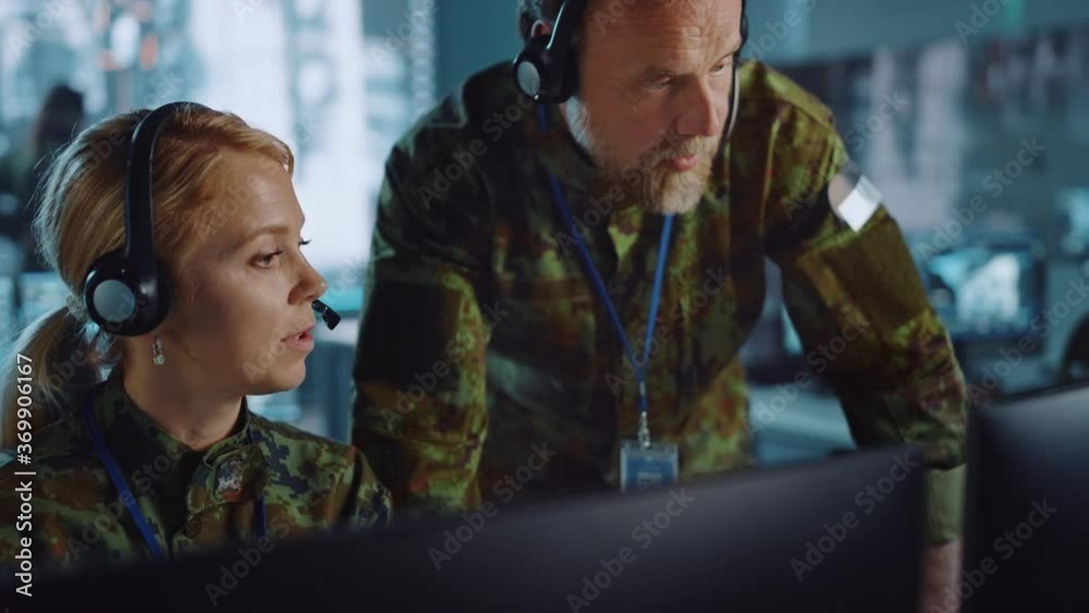 Poster military surveillance officers talking next to a computer screen in central office for cyber operati