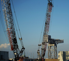 Fototapeta na wymiar Two cranes on a construction site on a sunny day