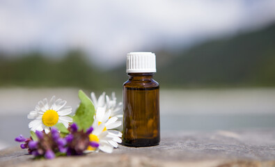 Flowers and bottles of essential oils for aromatherapy.