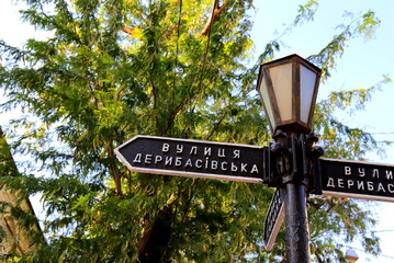 Vintage road sign stands on Deribasovskaya Street in the famous city Odessa, Ukraine. Deribasivska street is popular from Ukrainian and foreign tourists