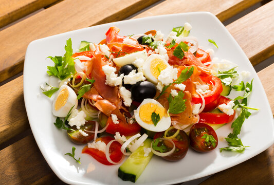 Bulgarian cuisine. Shopska salad with addition of quail egg and ham (Shepherds salad) ..