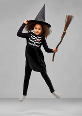halloween, holiday and childhood concept - smiling african american girl in black costume dress and...