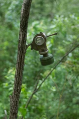 Keuken spatwand met foto Oud verlaten gasmasker dat aan een boom hangt © Albert Ziganshin