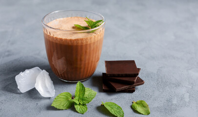 Chocolate cocktail, smoothie with ice, chocolate pieces and mint in a glass glass. Cooling drinks,...