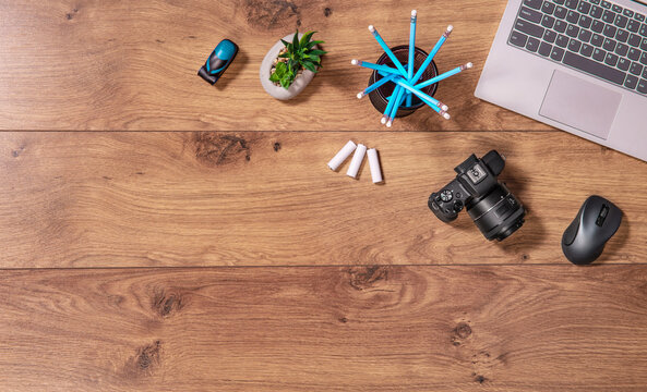 Photographers and graphic designers workplace. Flat lay top view of desk with laptop, camera. Wooden table copy space.