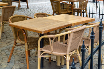 Wooden restaurant table and chairs set outside for clients.