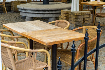 Wooden restaurant table and chairs set outside for clients.
