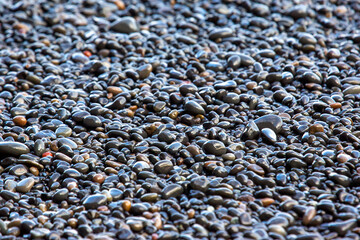 wet dark pebbles and rocks on the ocean coast