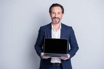 Photo of confident cheerful aged mature business guy hold computer netbook notebook showing...