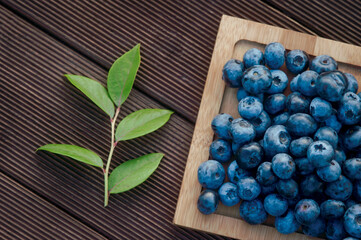 Fresh blueberry and leaf on wooden background. Texture blueberry berries close up. Vegan and vegetarian concept