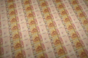 2 Ukrainian hryvnias bills printed in illegal money production conveyor. Collage of many fake...