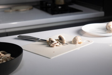 cutting white plastic board with champignon mushrooms on it. cooking process. High quality photo