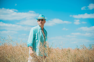 Mature man at field, lifestyle older men. Older senior man wear blue skirt and hat, casual style at field