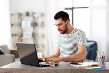 remote job, business and disinfection concept - man cleaning laptop computer keyboard with antiseptic wet wipe at home office