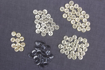 Plastic shiny buttons for clothes on a fabric background. Fashion and clothing. Factory industry.