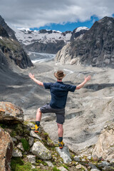 adventurer with outstreched arms over Oberaletsch Glacier in the Swiss Alps