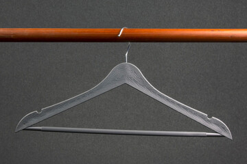 Empty clothes hanger hanging on a green background. Accessories and items for storing clothes.