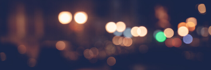 Night city lights, blurred image with bokeh and highlights, panorama banner format