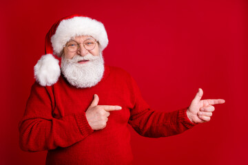 Fototapeta na wymiar Photo grey hair old man in santa claus headwear point index finger copyspace present magic miracle adverts discounts x-mas wear jumper isolated bright shine color background