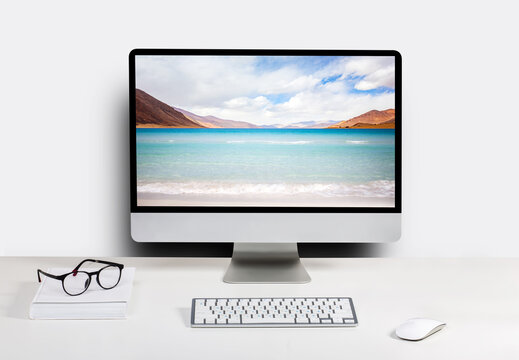 Computer with beach and ocean on screen monitor on white table Isolated in clipping path. free space on wall for text