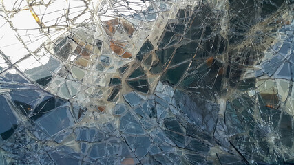 The broken windshield of the car. Glass splinter. An accident with the car. Dangerous traffic accident. Road accident. Glass background.