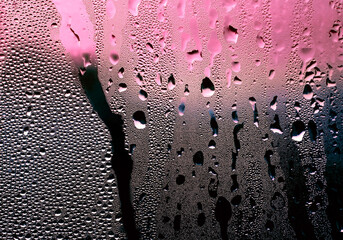 Natural water drops on glass, abstract colors