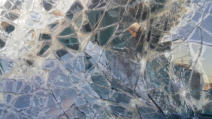 The broken windshield of the car. Glass splinter. An accident with the car. Dangerous traffic accident. Road accident. Glass background.