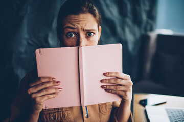 Half length portrait of wondered hipster student read literature book with confused plot and...