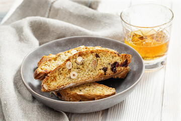 Italian biscotti cookies in grey plate and sweet wine Vin Santo.