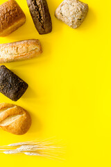 Top view of different loaves of bread and wheat ears copy space