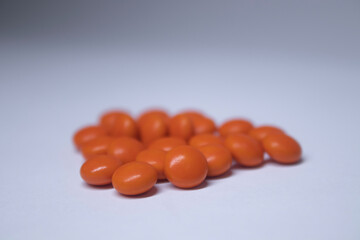 pile of orange pills on a white background. medicine and disease concept. Isolated. High quality photo