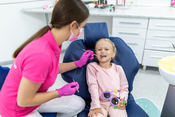 Little girl sitting in the dentists office at teeth check
