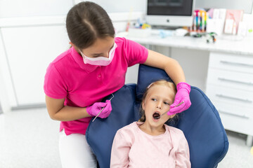 Little girl sitting in the dentists office at teeth check
