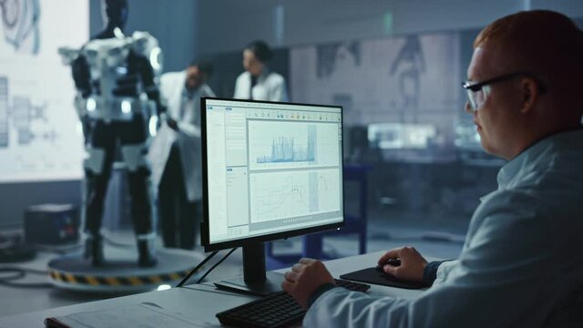 In Robotics Development Laboratory: Chief Analyst Uses Computer, Female Engineer, Top Male Scientist Work on Bionics Exoskeleton Prototype. Designing Powered Exosuit to Help Disabled People.
