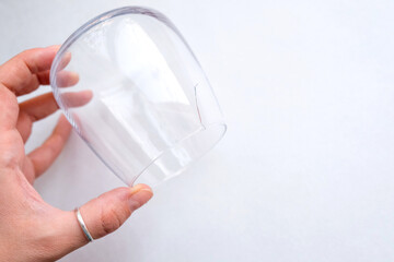 Crack in the glass. Holds a transparent glass in his hand. View from above