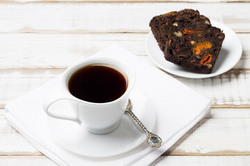 Natural drink chicory in a white Cup with a saucer with fruit and nut bread, on a wooden table. Breakfast